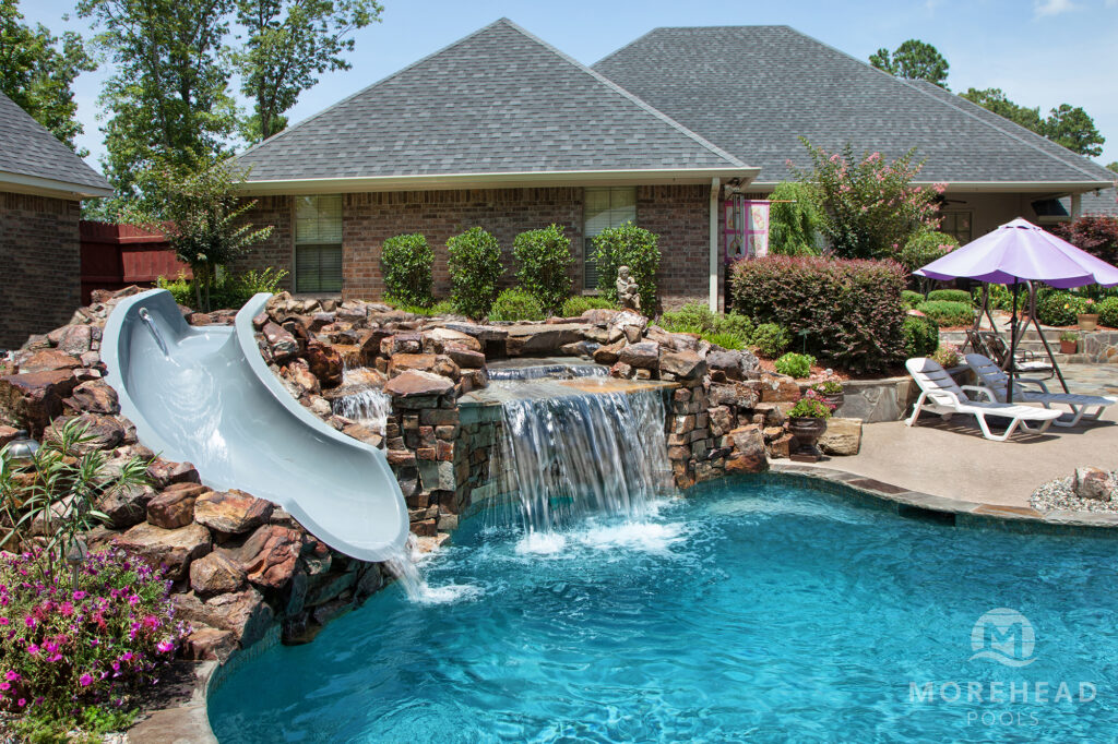 Luxury swimming pool with slide and rock waterfall