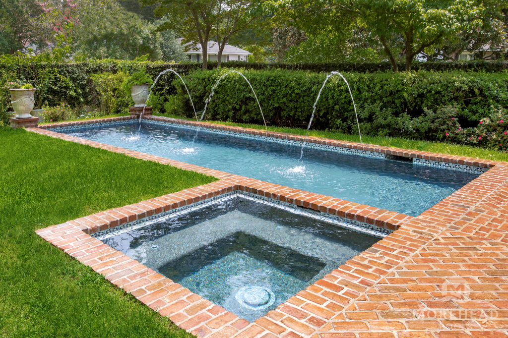 Cocktail swimming pool with spa, laminar deck jets and brick coping
